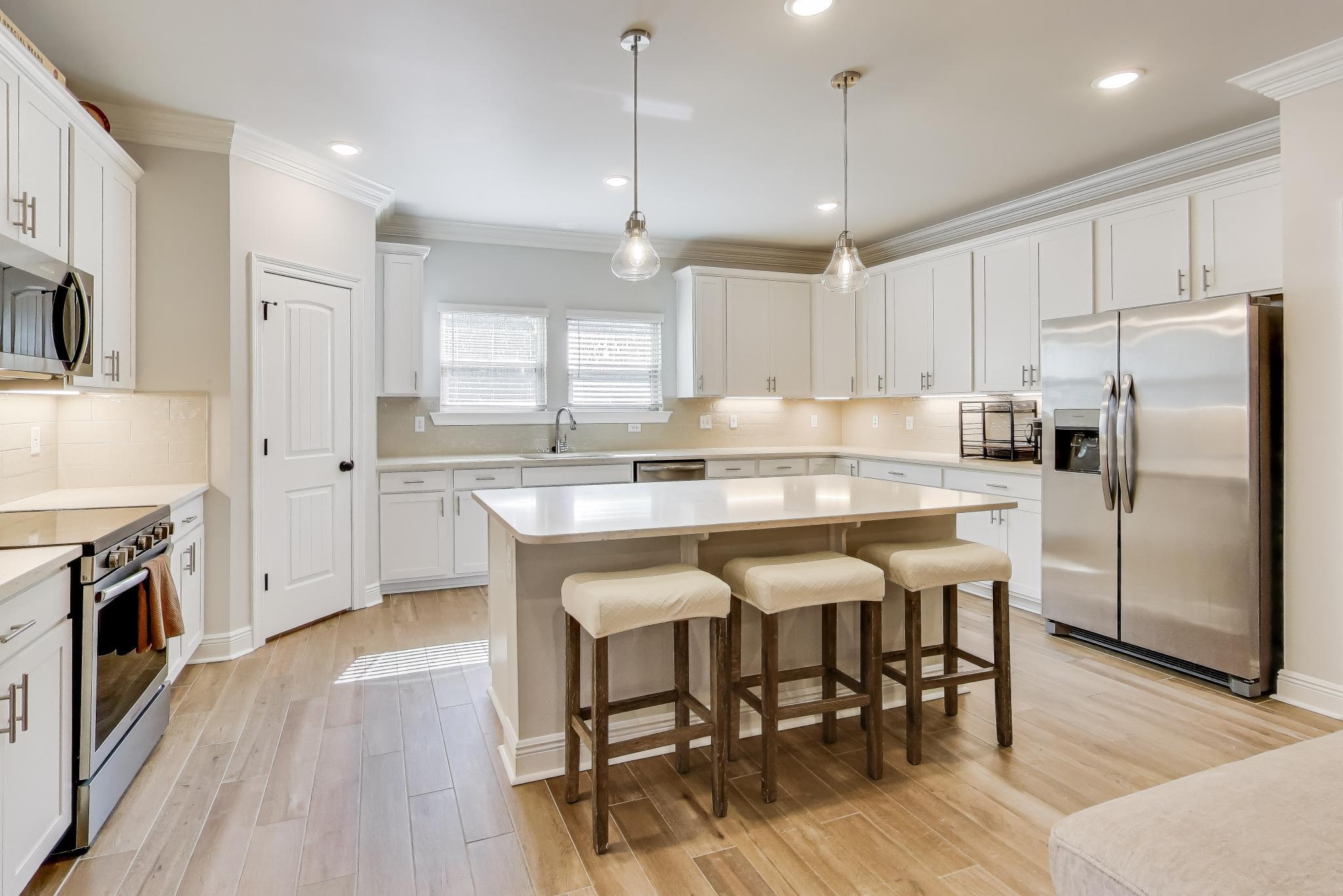 46 East Tweet Street Freeport, FL 32439 - Photo 13 of 59 a kitchen with stainless steel appliances granite countertop a dining table chairs stove refrigerator and microwave