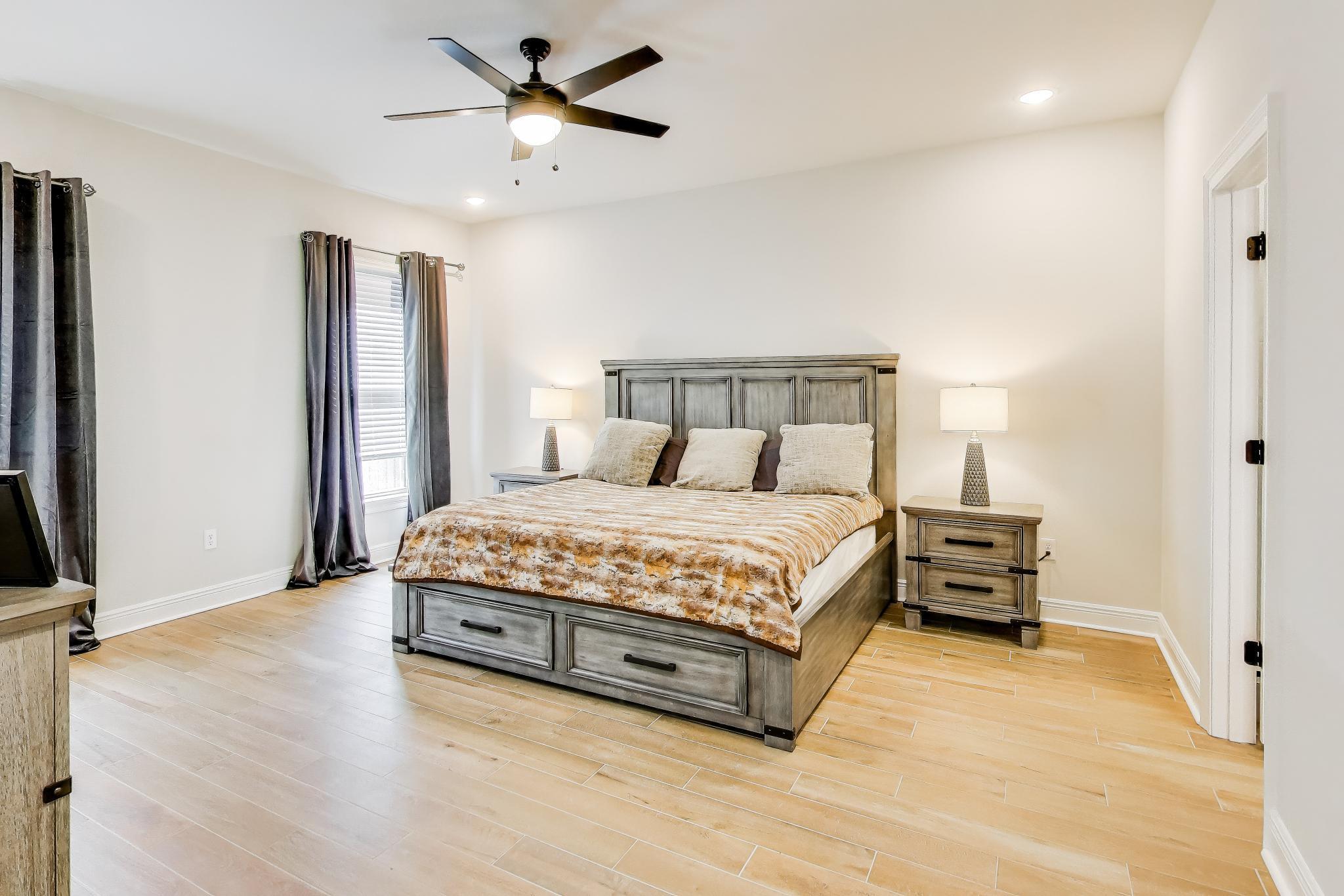 46 East Tweet Street Freeport, FL 32439 - Photo 17 of 59 a spacious bedroom with a bed and a chandelier