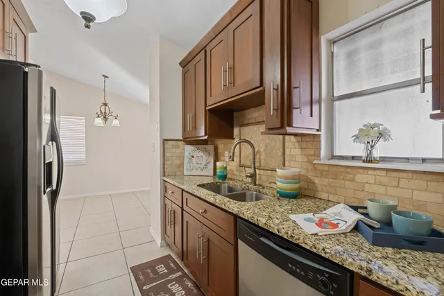 a kitchen with granite countertop a sink stainless steel appliances and cabinets