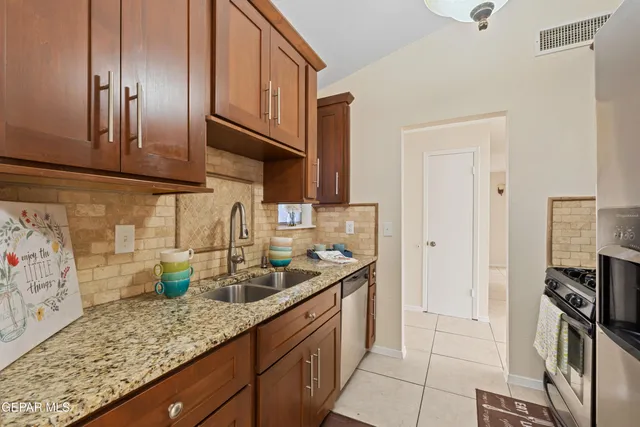 a kitchen with stainless steel appliances granite countertop a sink stove and refrigerator