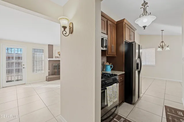 a kitchen with stainless steel appliances granite countertop a refrigerator and a stove top oven