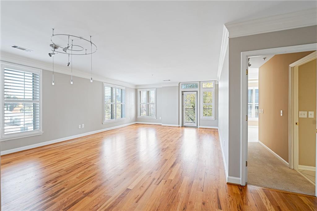 3334 Peachtree Road Northeast, Unit 312 Atlanta, GA 30326 - Photo 13 of 79 a view of an empty room with wooden floor and a window