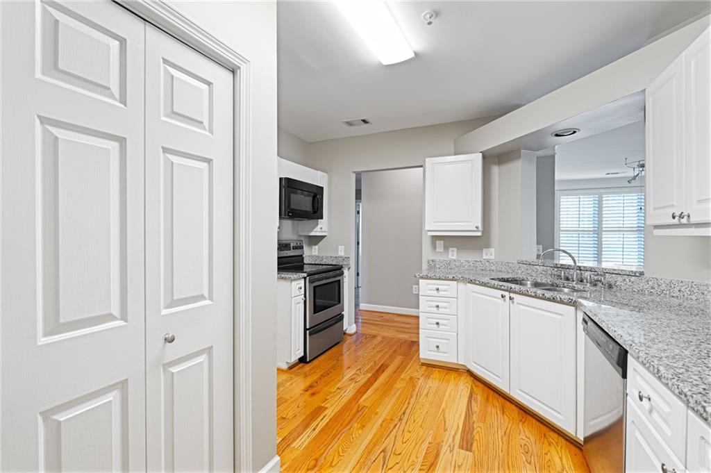 3334 Peachtree Road Northeast, Unit 312 Atlanta, GA 30326 - Photo 10 of 79 a large kitchen with cabinets wooden floor and stainless steel appliances