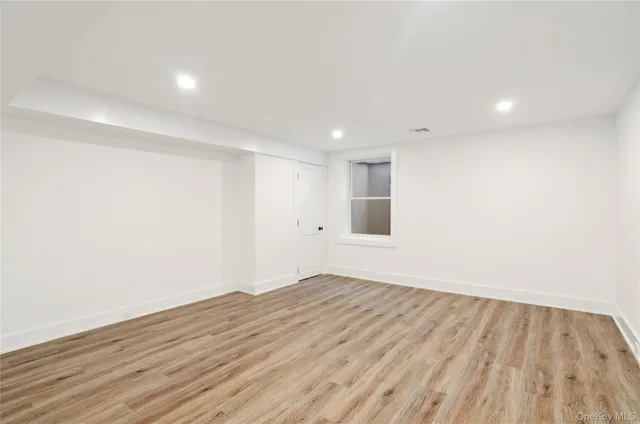 a view of an empty room with wooden floor and entryway