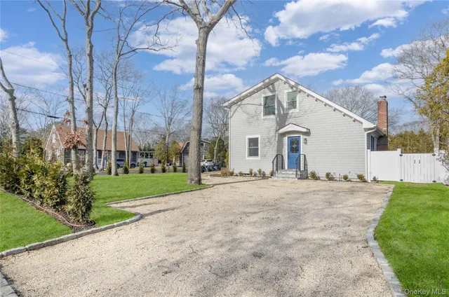 a view of a white house with a yard and pathway
