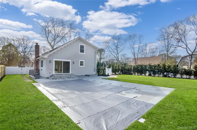 a view of a house with backyard and wooden fence