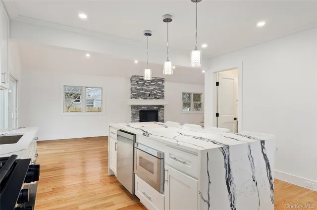 a kitchen that has a sink a stove and a wooden floor