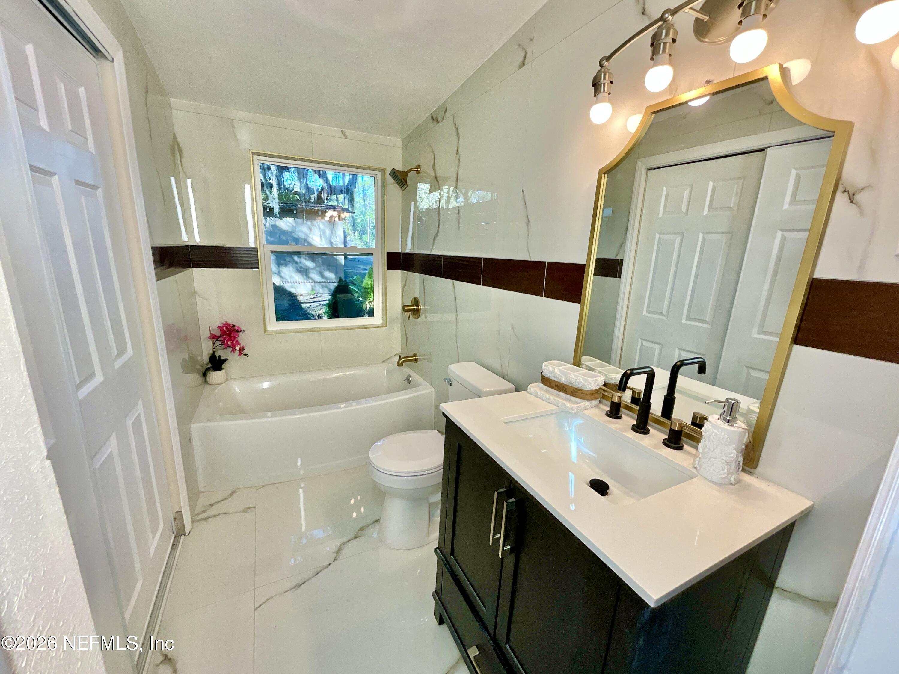 111 2nd Street Melrose, FL 32666 - Photo 17 of 36 a bathroom with a sink toilet tub and shower