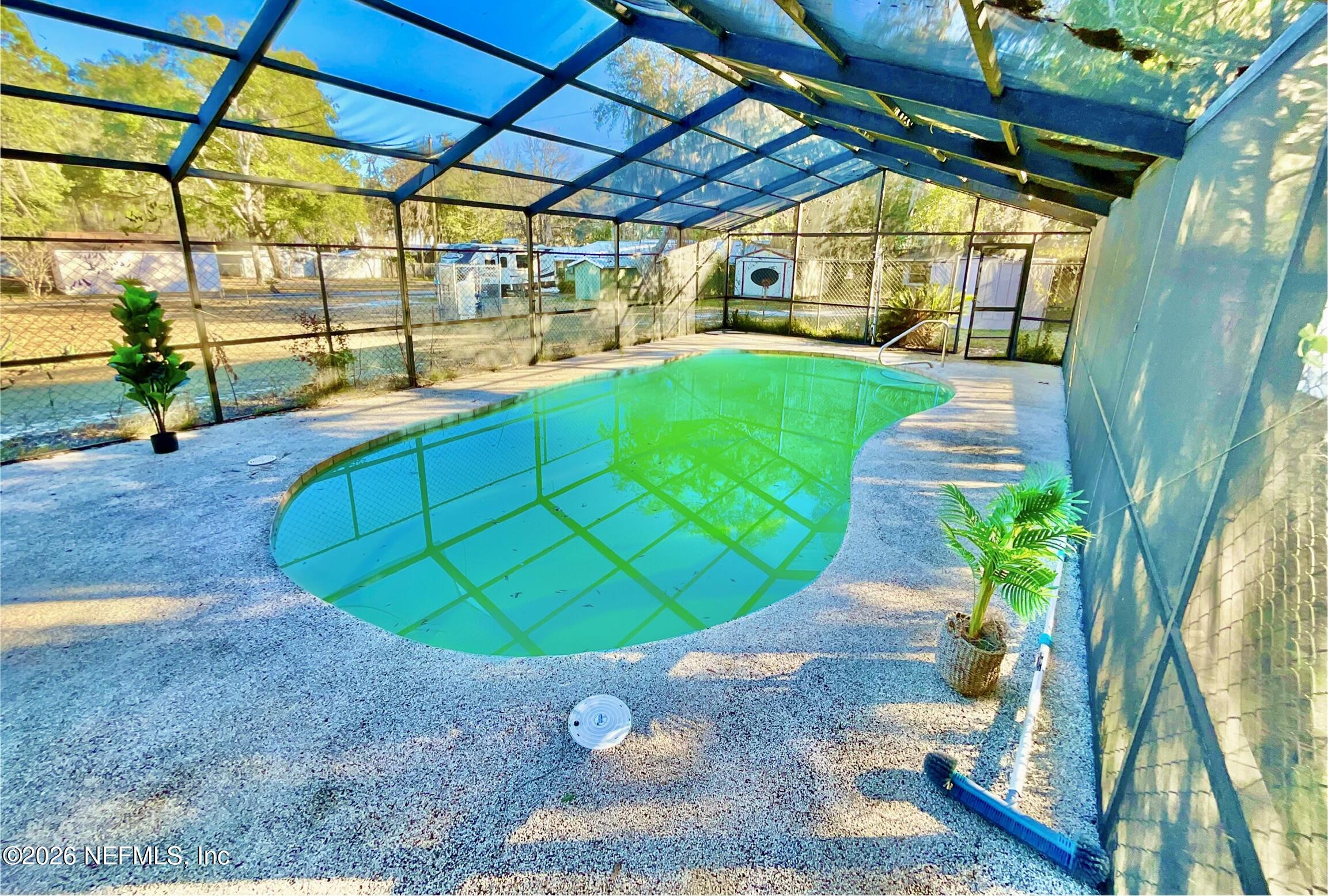 111 2nd Street Melrose, FL 32666 - Photo 30 of 36 a view of a swimming pool with a patio and plants