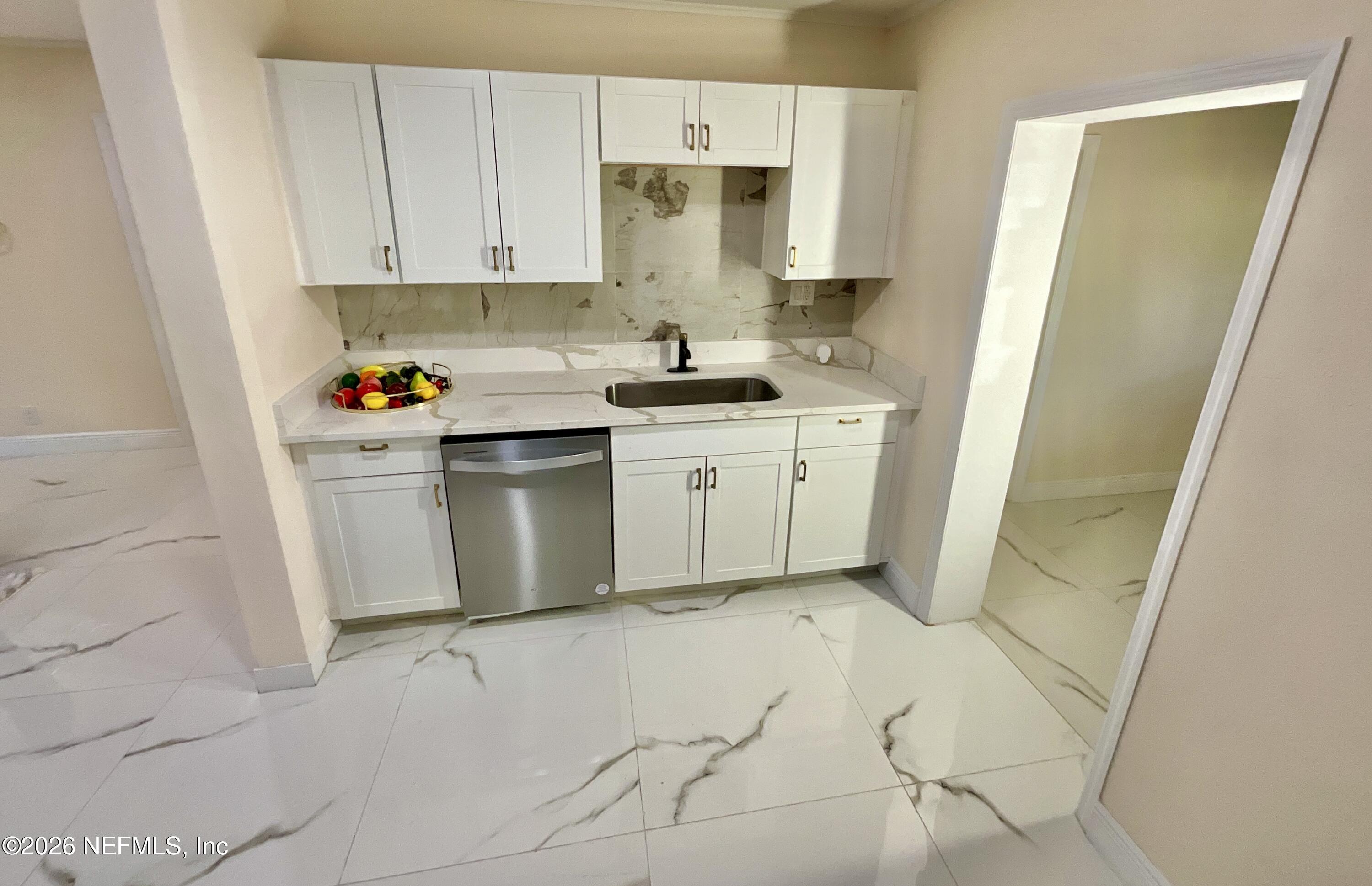 111 2nd Street Melrose, FL 32666 - Photo 7 of 36 a kitchen with stainless steel appliances a white refrigerator a sink a stove and white cabinets