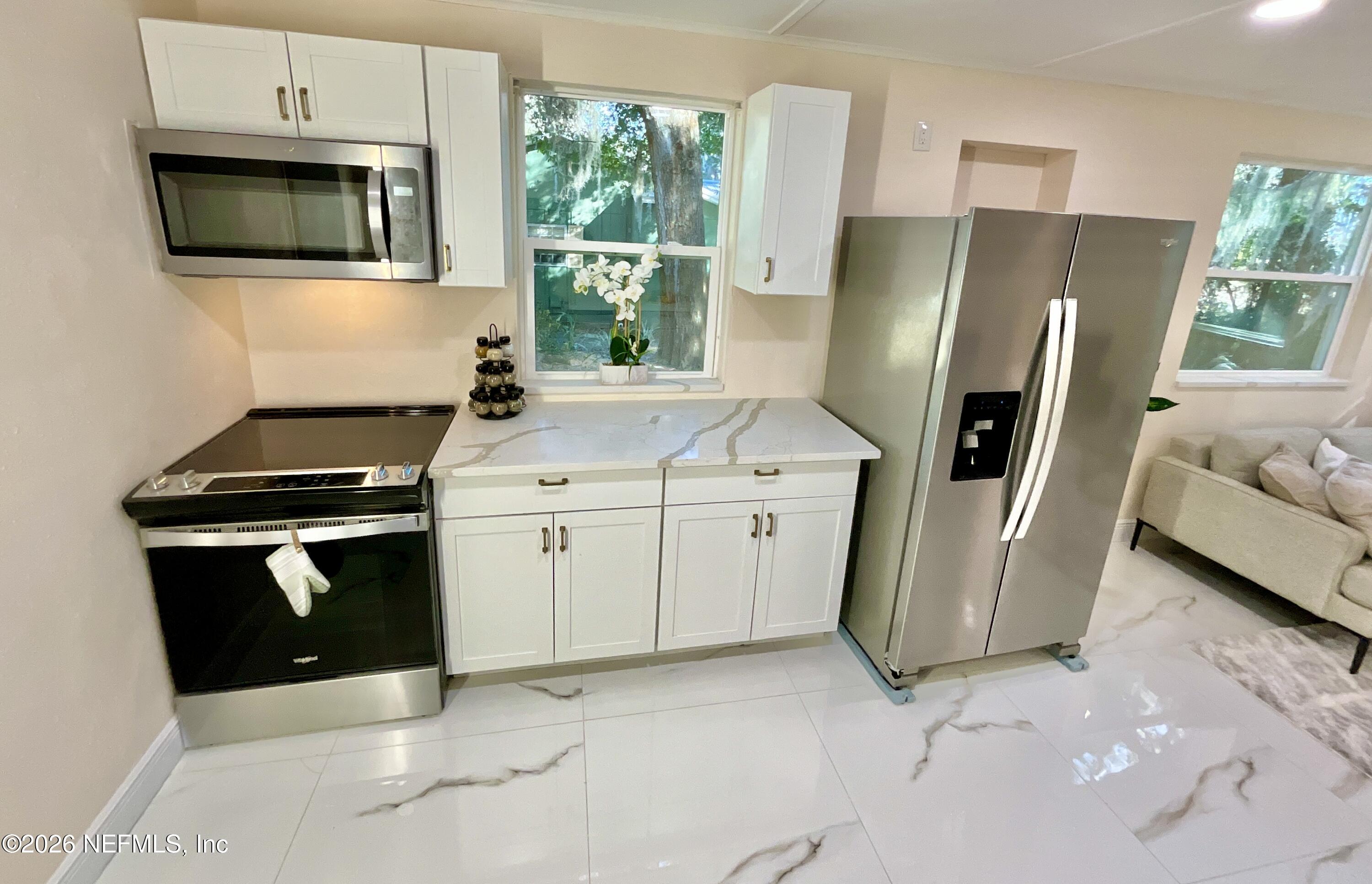 111 2nd Street Melrose, FL 32666 - Photo 8 of 36 a kitchen with appliances a sink and a stove
