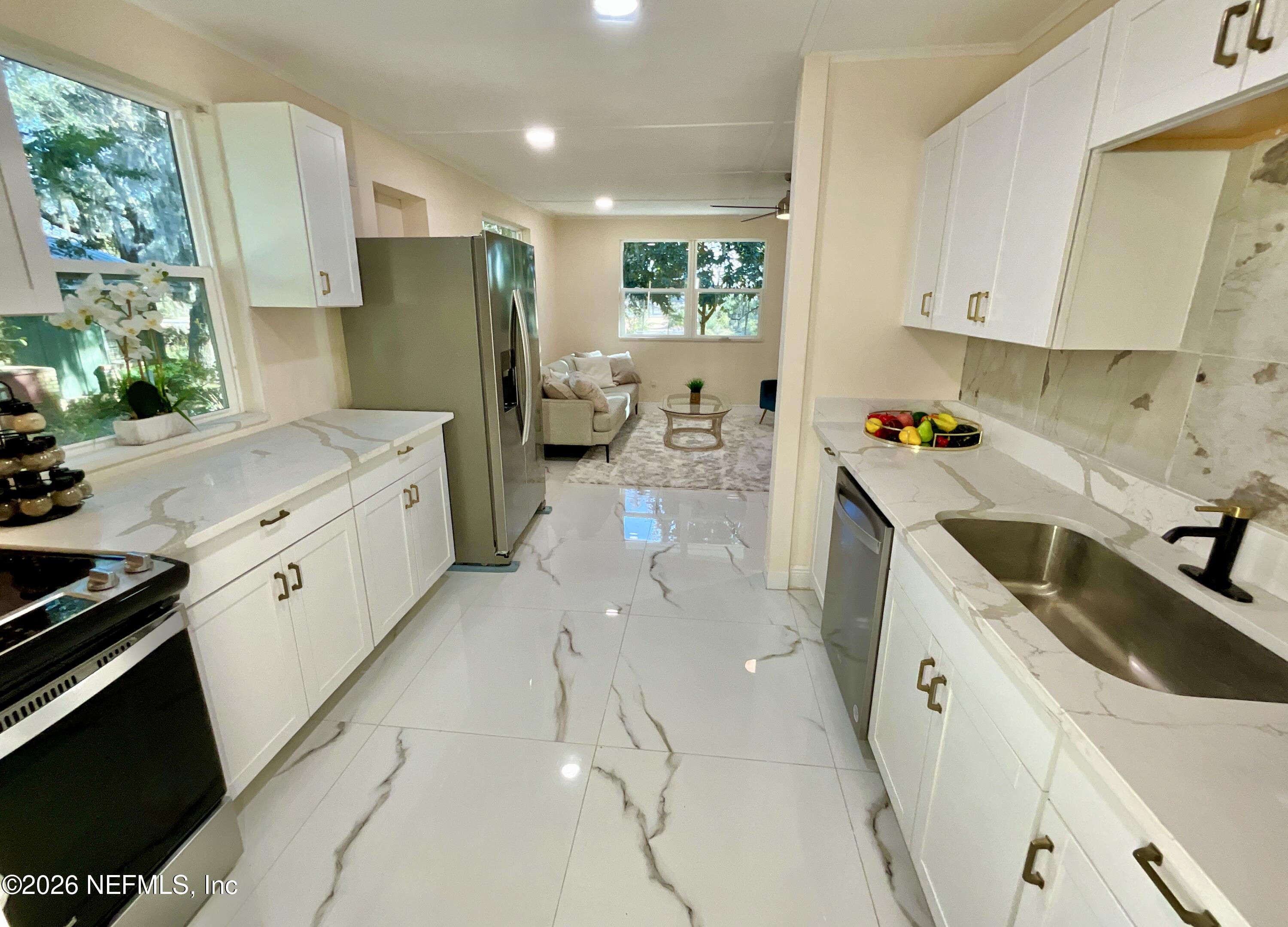 111 2nd Street Melrose, FL 32666 - Photo 9 of 36 a kitchen with sink refrigerator and cabinets