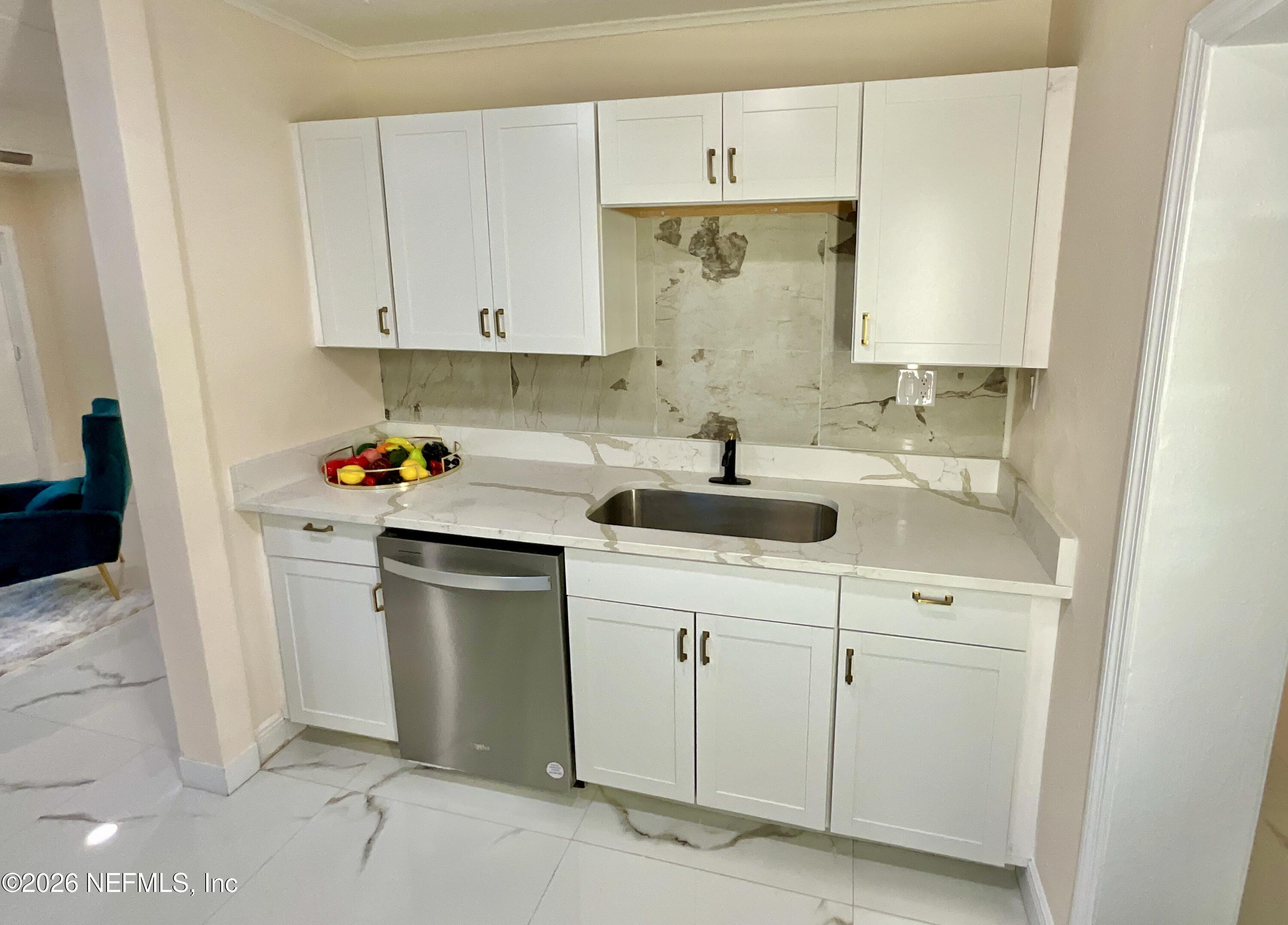 111 2nd Street Melrose, FL 32666 - Photo 10 of 36 a kitchen with white cabinets and sink