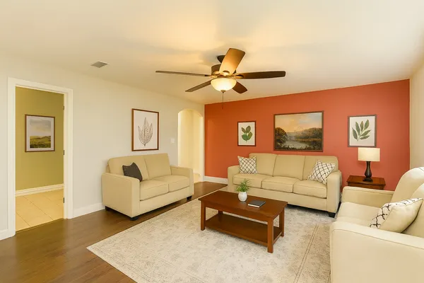 a living room with furniture and a ceiling fan