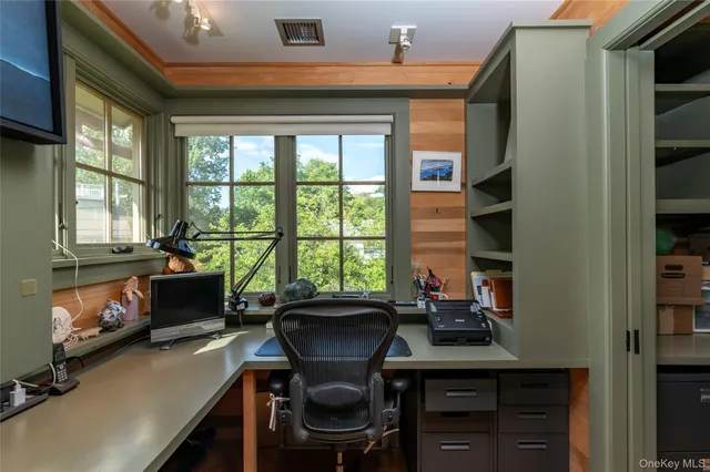 a view of a workspace with furniture and a window