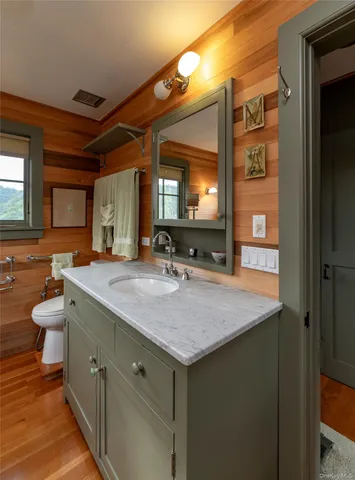 a bathroom with a granite countertop sink a toilet and mirror