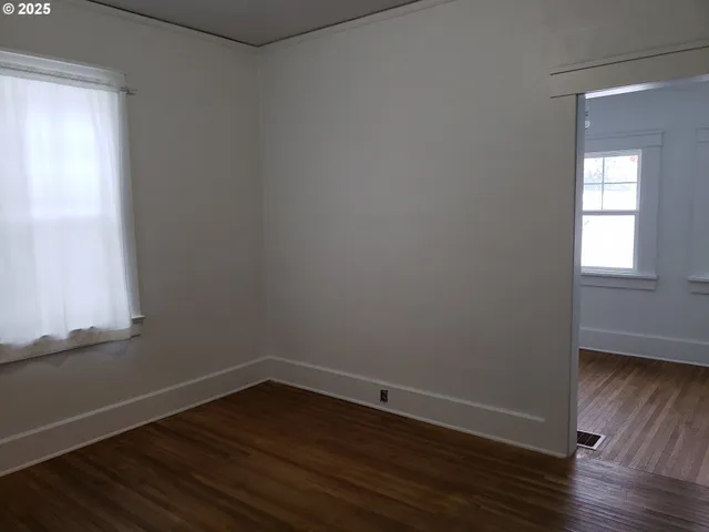 a view of a small space with wooden floor and a window