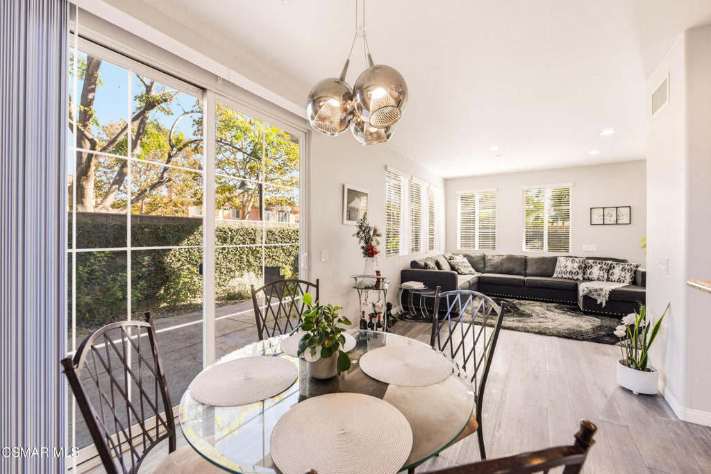 2964 Camelita Way, Unit C Simi Valley, CA 93063 - Photo 9 of 42 a dining room with wooden floor a chandelier a glass table and chairs