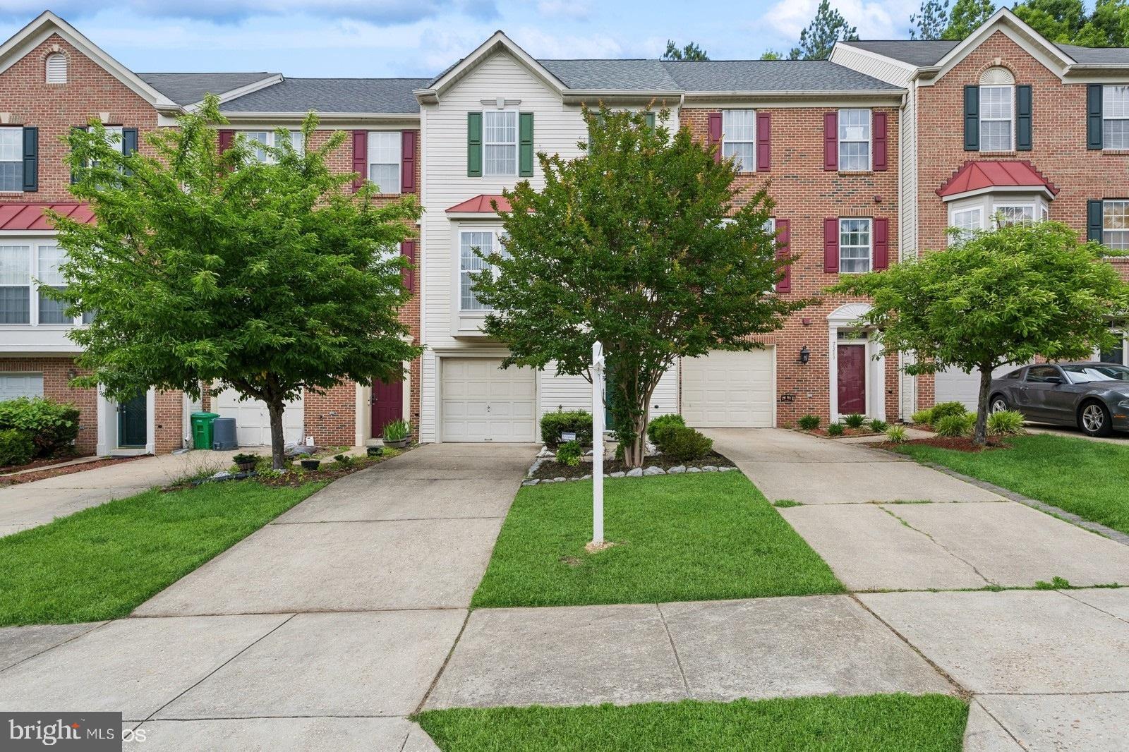 a front view of a house with a yard and trees