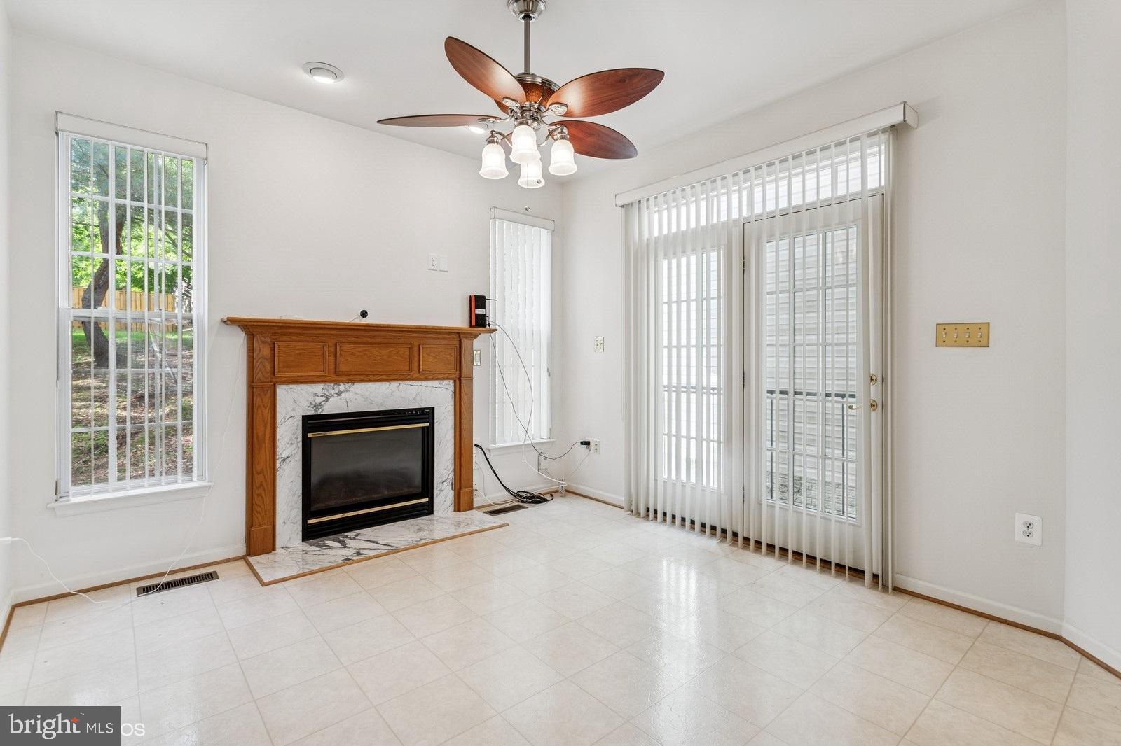 7315 Serenade Circle Clinton, MD 20735 - Photo 15 of 36 a view of livingroom with a fireplace ceiling fan and windows