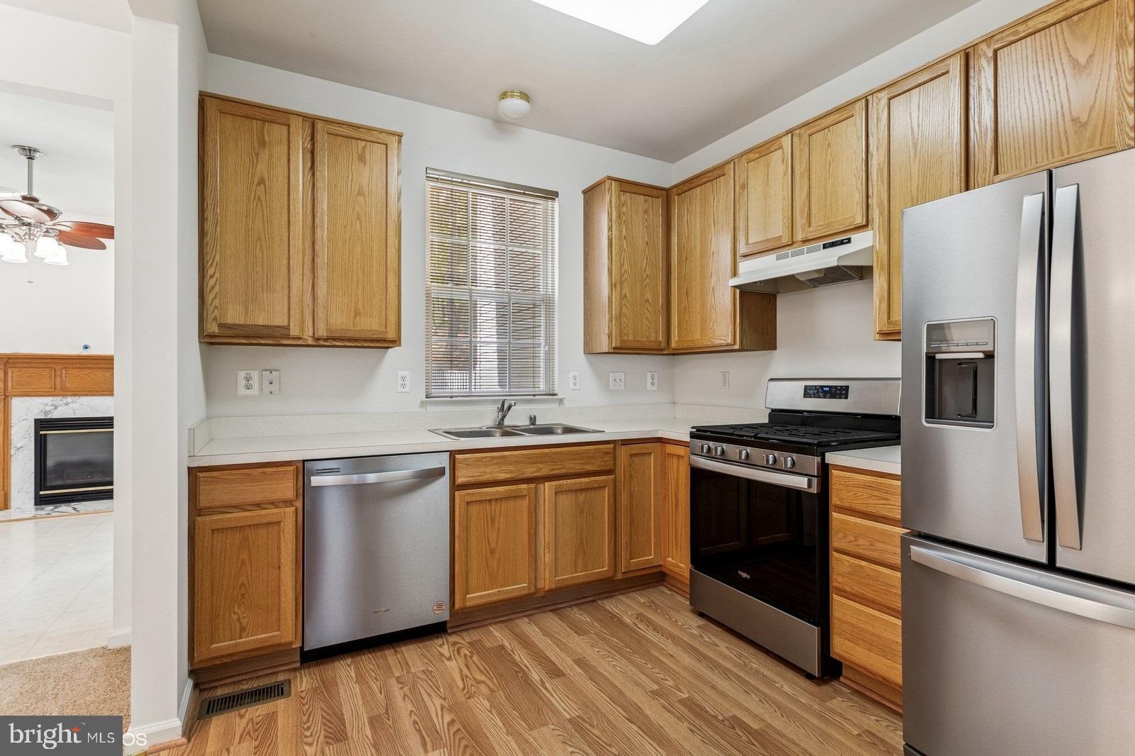 7315 Serenade Circle Clinton, MD 20735 - Photo 19 of 36 a kitchen with stainless steel appliances granite countertop a stove a sink dishwasher a refrigerator and cabinets with wooden floor
