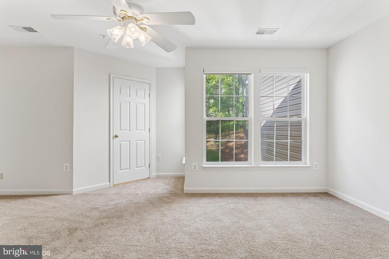 7315 Serenade Circle Clinton, MD 20735 - Photo 26 of 36 an empty room with chandelier fan and windows