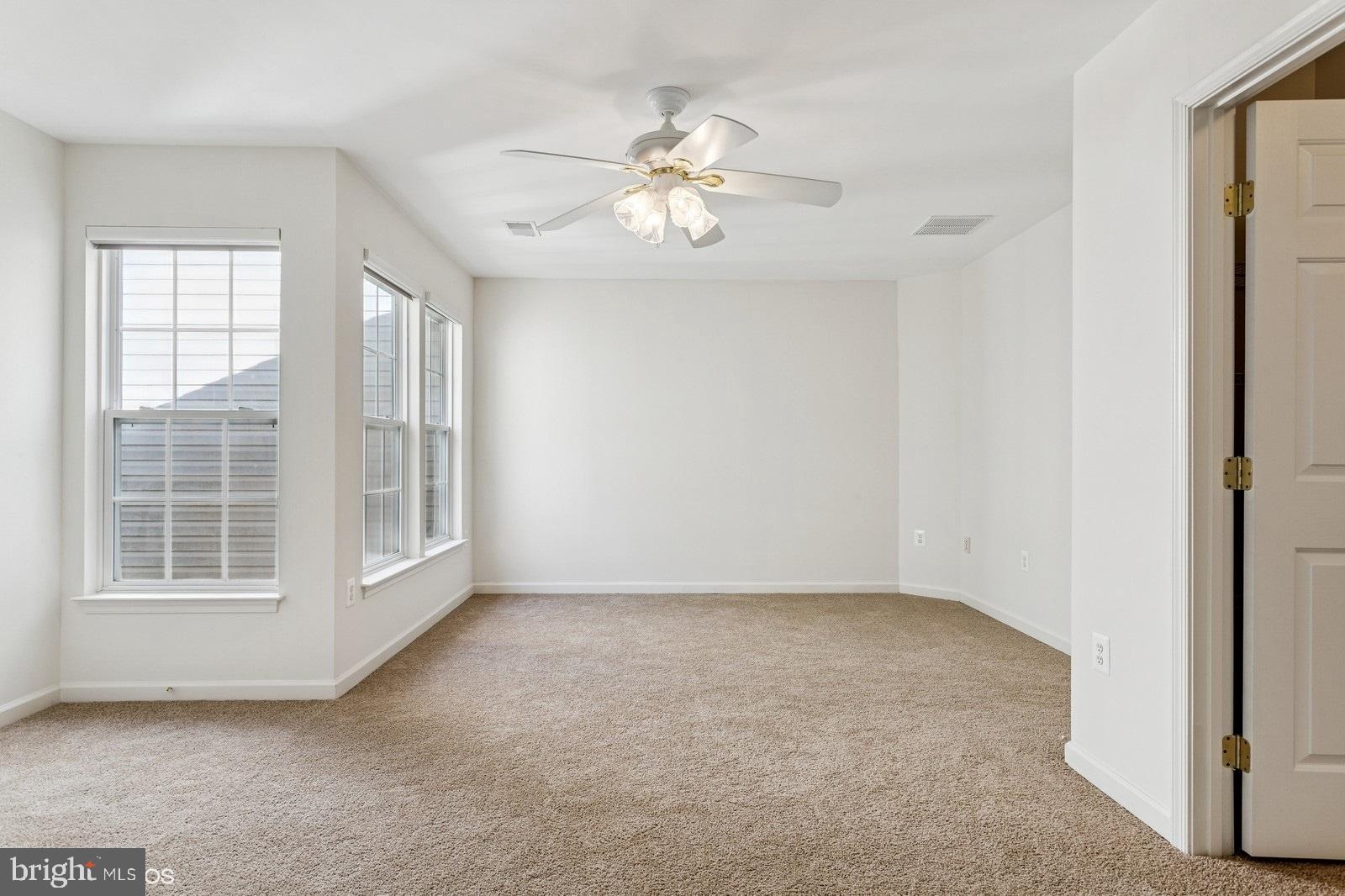 7315 Serenade Circle Clinton, MD 20735 - Photo 30 of 36 an empty room with chandelier fan and windows