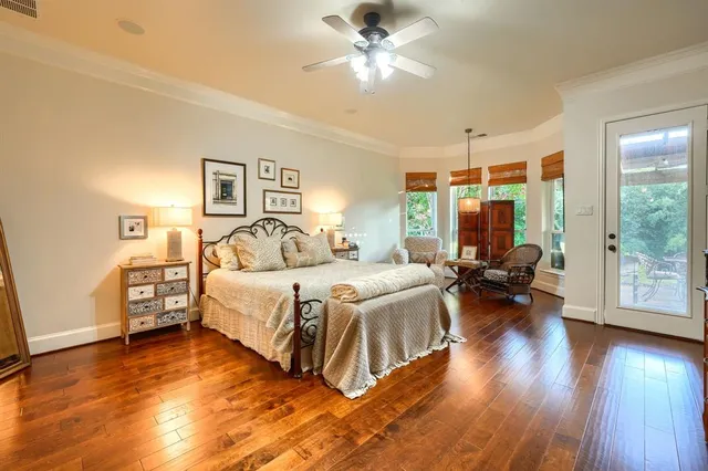 a spacious bedroom with a bed and wooden floor