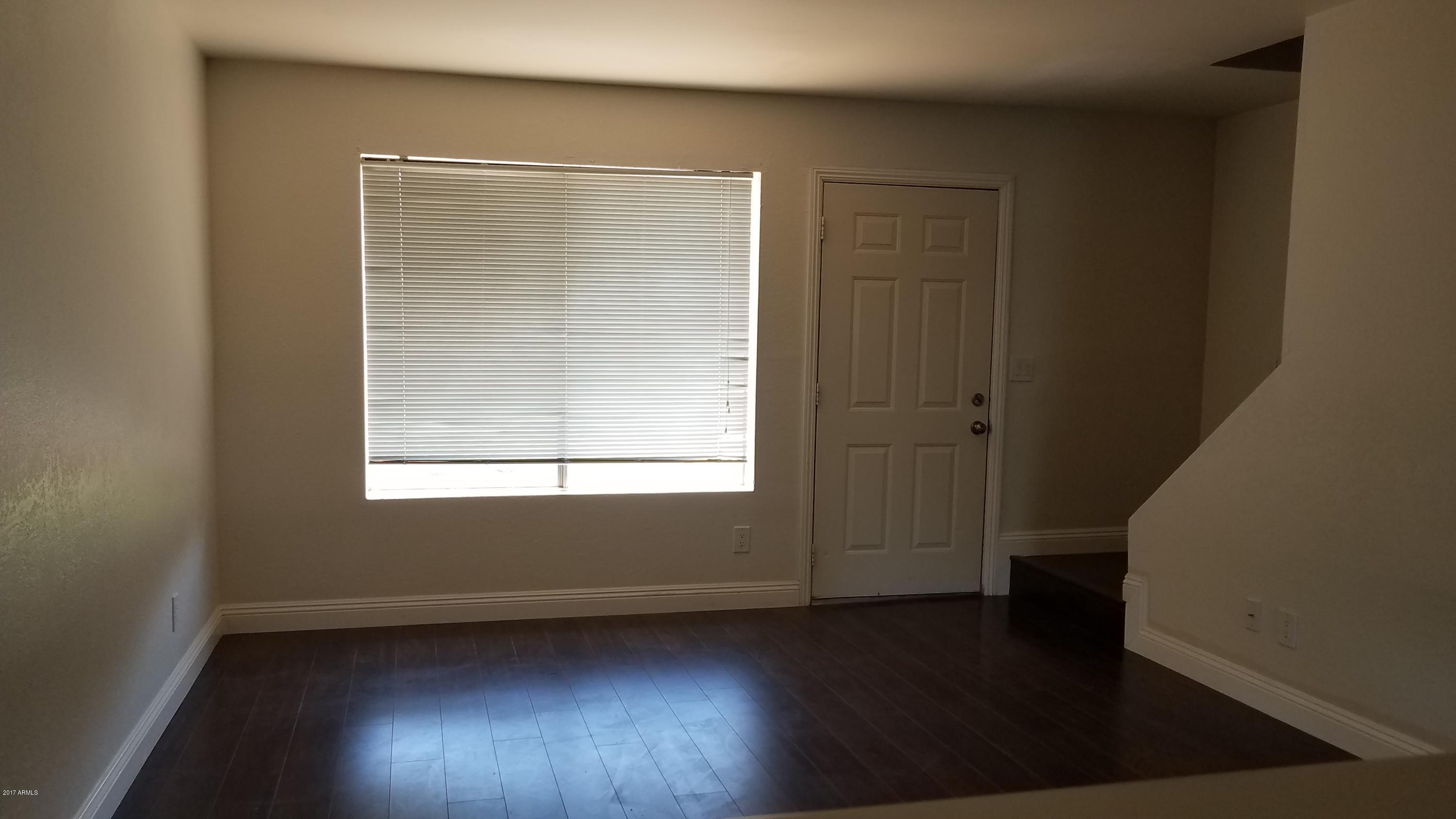 19601 North 7th Street, Unit 1049 Phoenix, AZ 85024 - Photo 6 of 26 an empty room with wooden floor and windows