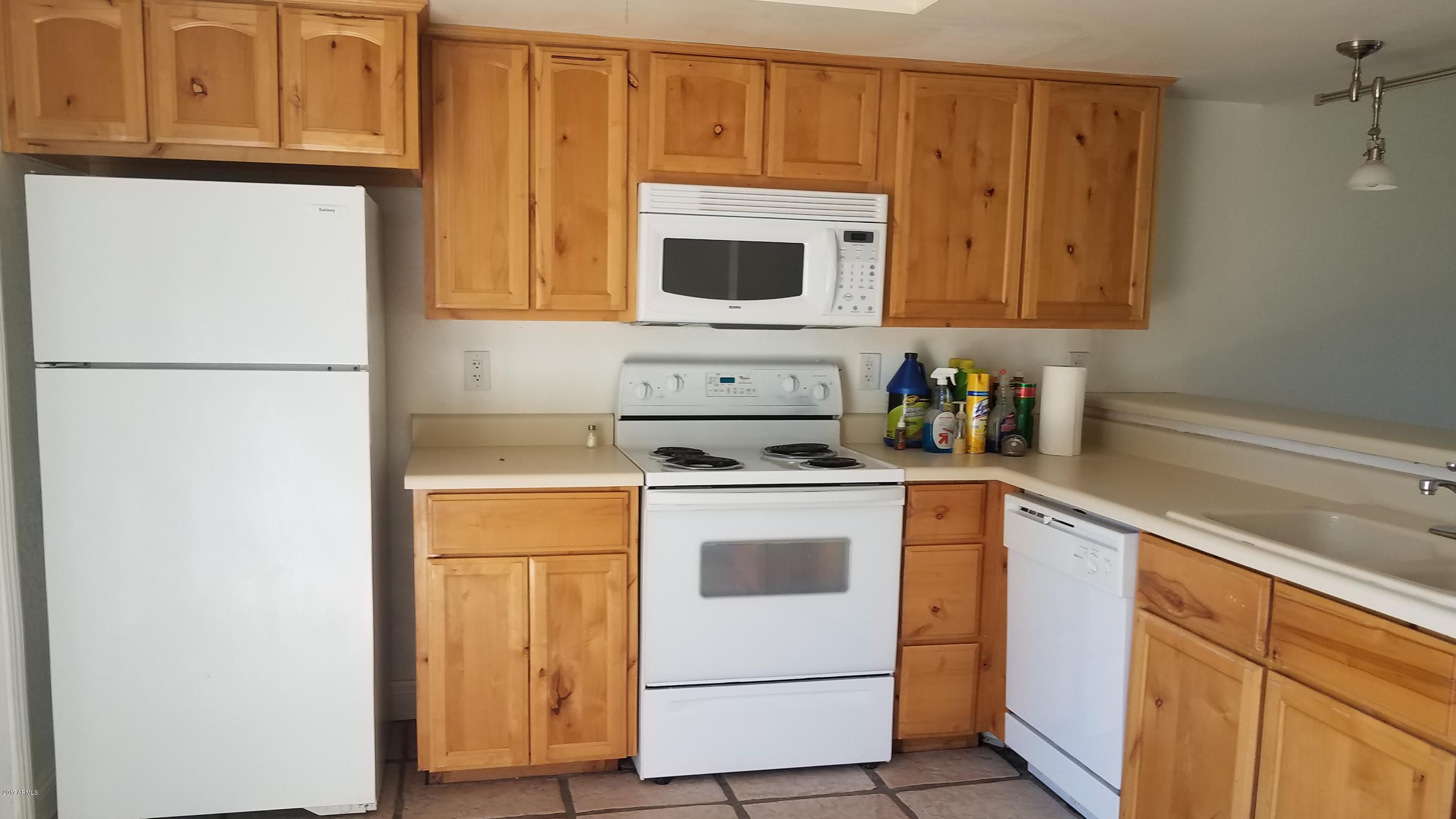 19601 North 7th Street, Unit 1049 Phoenix, AZ 85024 - Photo 7 of 26 a kitchen with stainless steel appliances granite countertop a refrigerator stove a sink and dishwasher with wooden floor