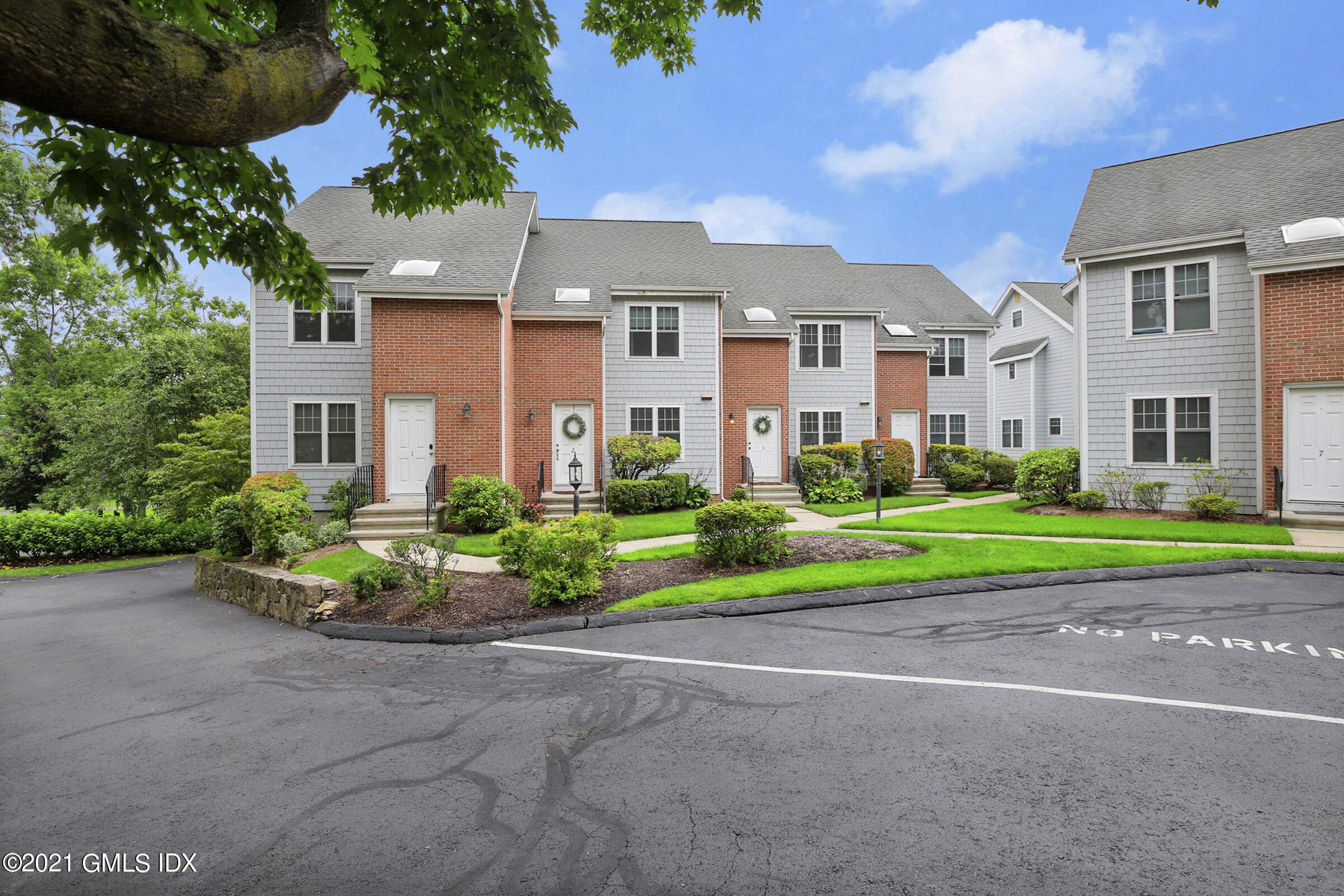 100 Strickland Road, Unit 1 Cos Cob, CT 06807 - Photo 26 of 29 a front view of a house with a yard and outdoor seating