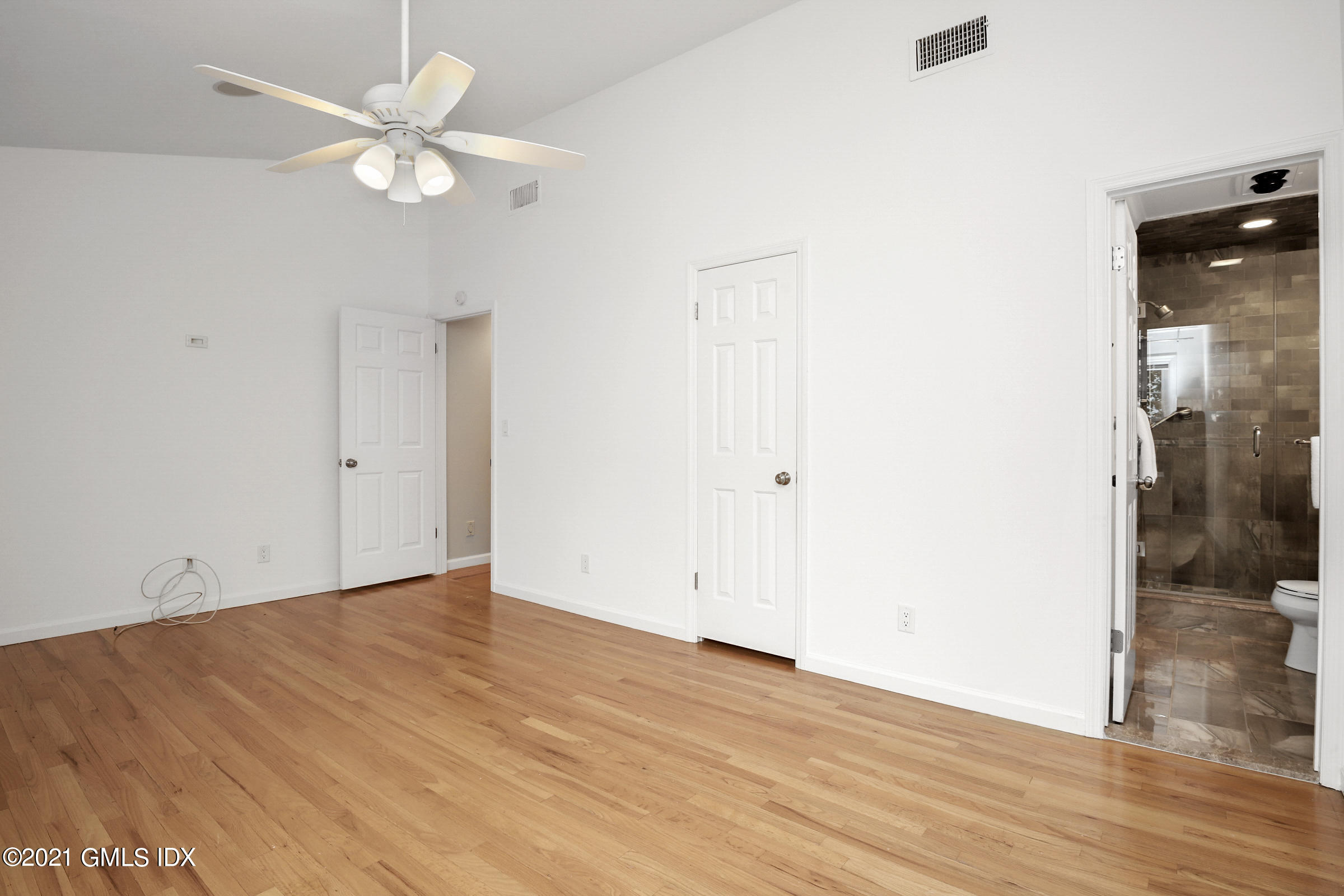 100 Strickland Road, Unit 1 Cos Cob, CT 06807 - Photo 10 of 29 an empty room with wooden floor and fan
