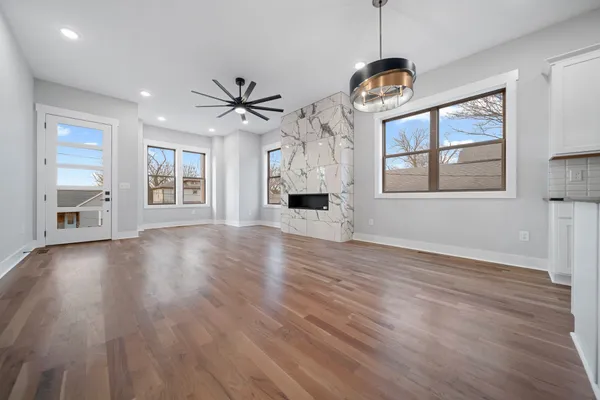 a view of an empty room with a window and wooden floor