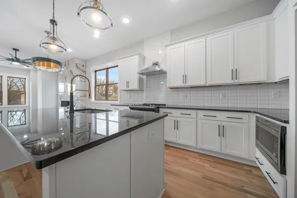 a kitchen with granite countertop a sink stainless steel appliances and cabinets
