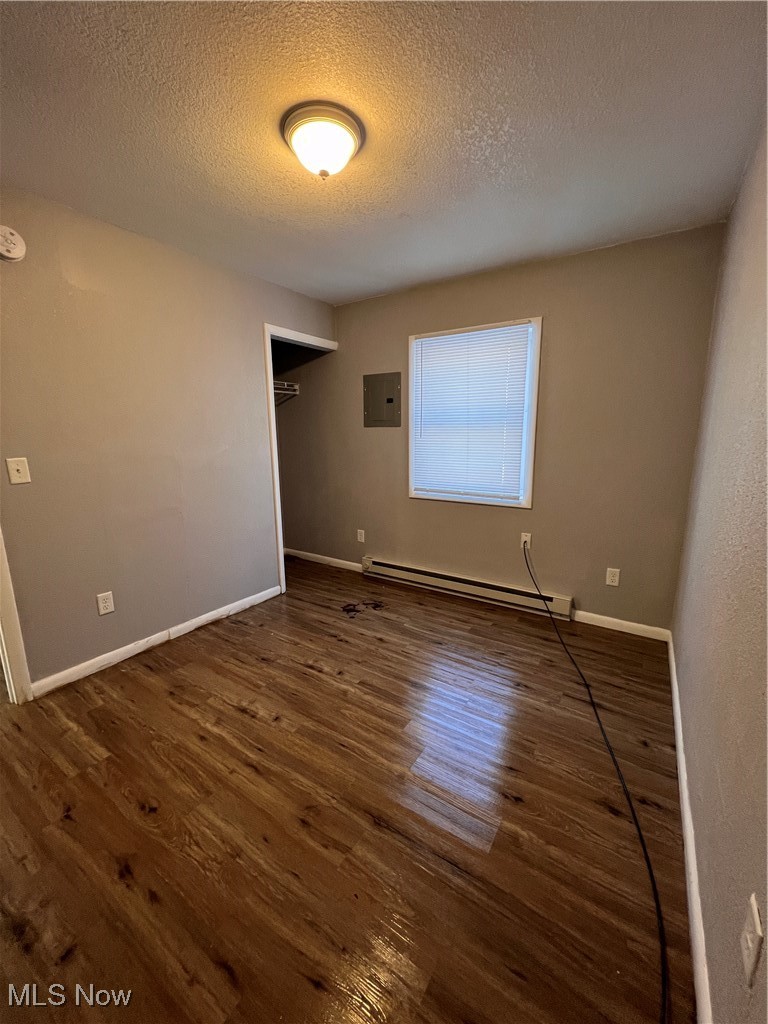 1724 Youngstown Kingsville Road, Unit 4 Vienna, OH 44473 - Photo 10 of 11 Spare room with electric panel, baseboard heating, baseboards, and wood finished floors