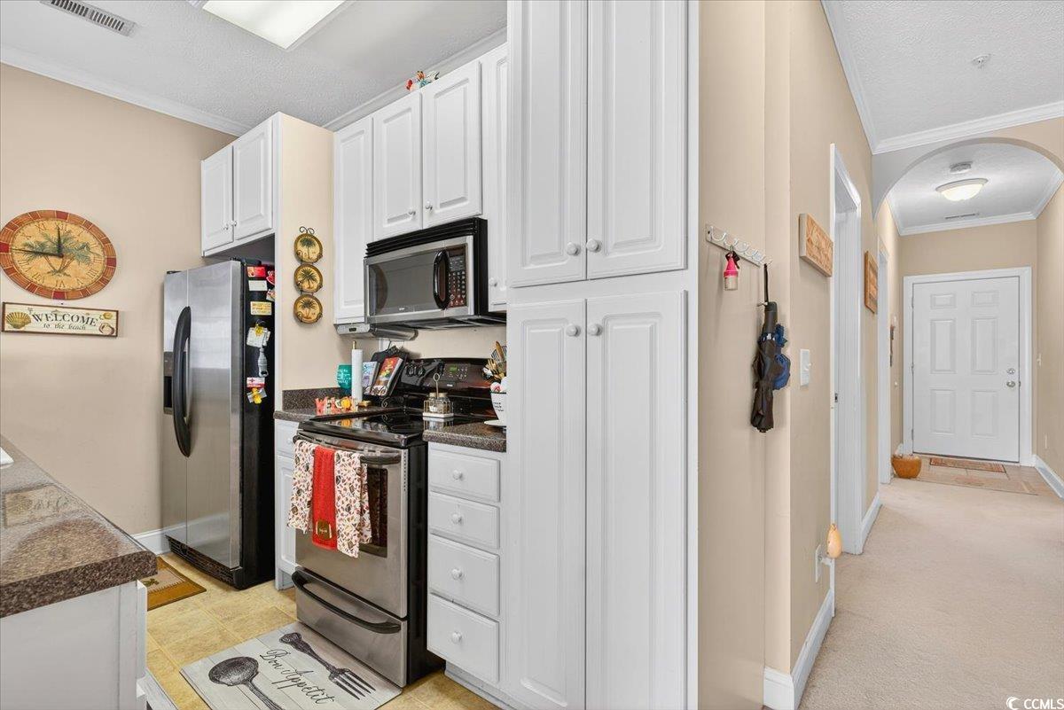 131 Waypoint Ridge Avenue, Unit 24 Little River, SC 29566 - Photo 17 of 39 Kitchen with crown molding, stainless steel appliances, white cabinetry, and arched walkways