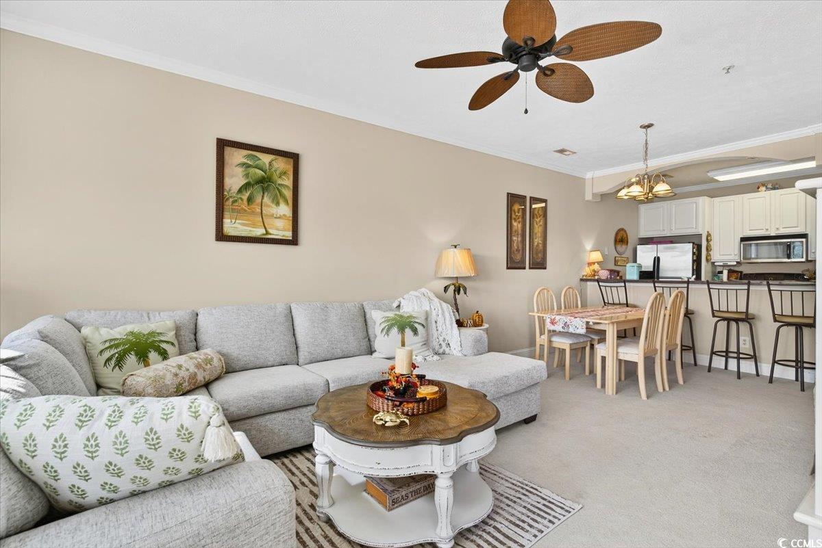 131 Waypoint Ridge Avenue, Unit 24 Little River, SC 29566 - Photo 21 of 39 Living room featuring ornamental molding, light colored carpet, a ceiling fan, and a chandelier