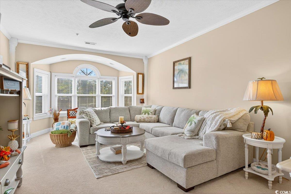 131 Waypoint Ridge Avenue, Unit 24 Little River, SC 29566 - Photo 22 of 39 Carpeted living area featuring crown molding, ceiling fan, and a textured ceiling