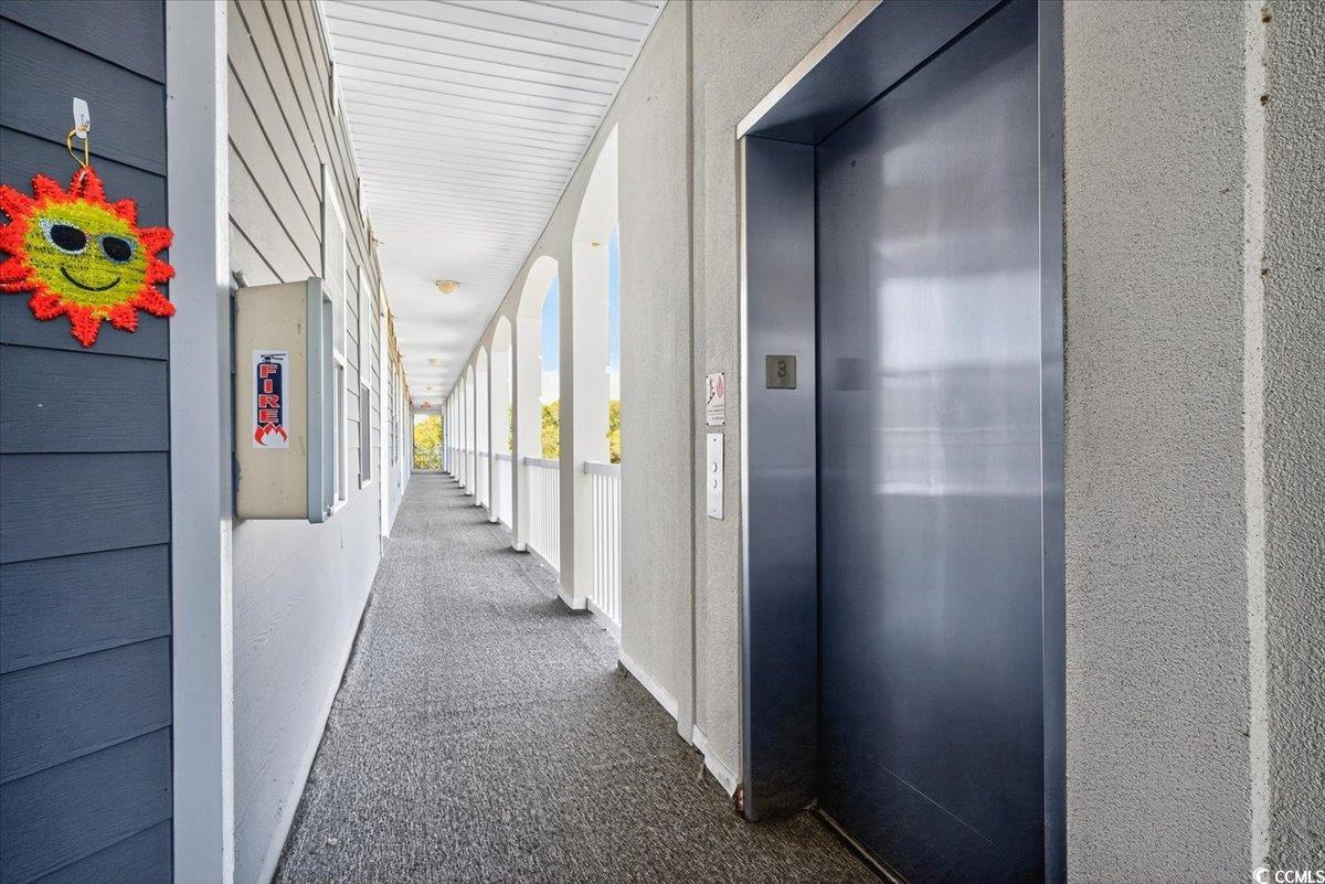 131 Waypoint Ridge Avenue, Unit 24 Little River, SC 29566 - Photo 7 of 39 Hallway featuring elevator, carpet flooring, and a textured wall