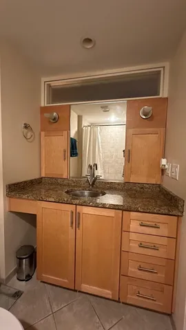 a bathroom with a granite countertop sink and a mirror
