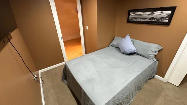 a bed sitting in a bedroom next to a window