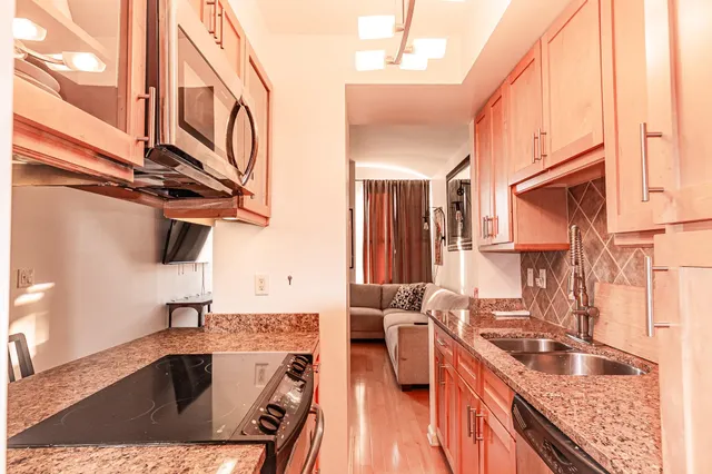 a kitchen with stainless steel appliances granite countertop a sink stove and cabinets