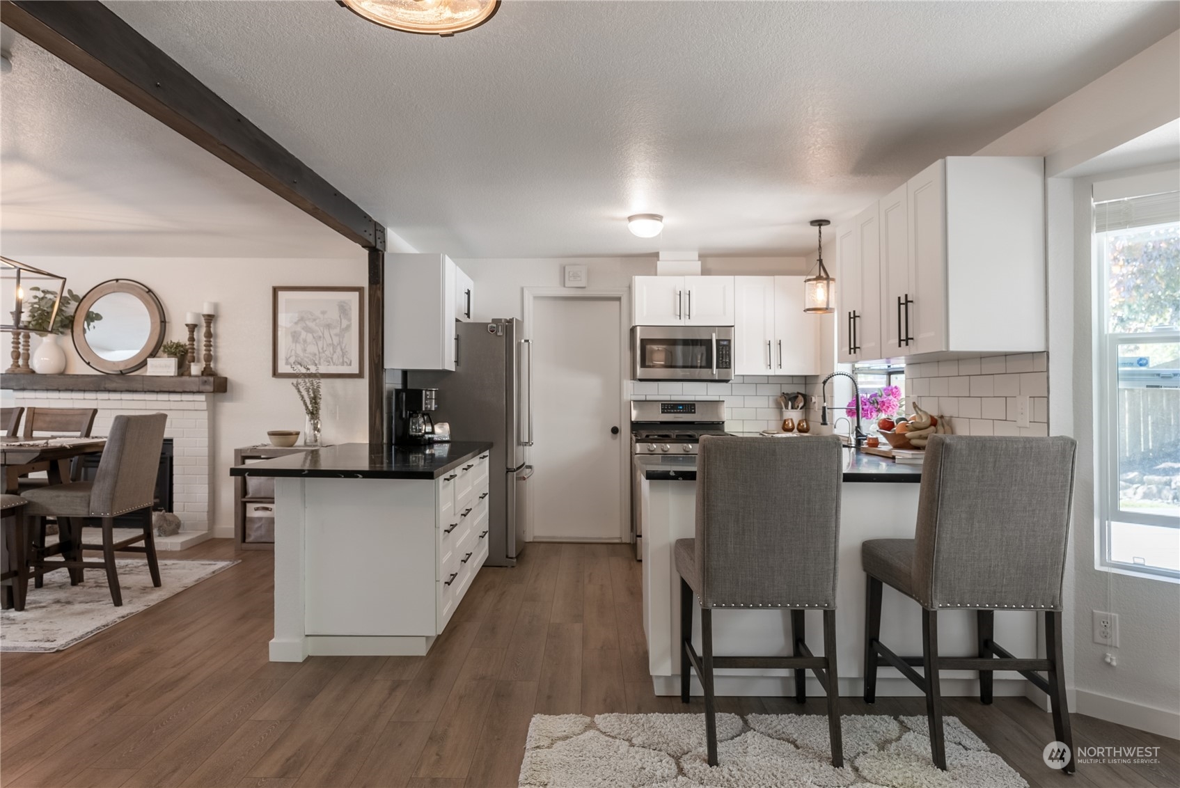 16520 4th Drive Southeast Bothell, WA 98012 - Photo 4 of 32 a kitchen with stainless steel appliances kitchen island granite countertop a table chairs refrigerator and microwave