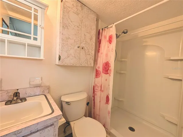 a bed sitting in a spacious bedroom next to a window