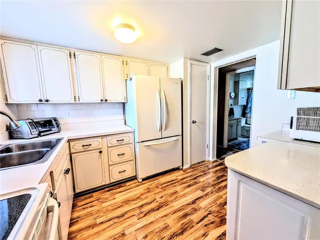 a kitchen with stainless steel appliances a refrigerator sink and cabinets