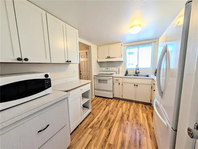 a kitchen with a sink a stove and cabinets