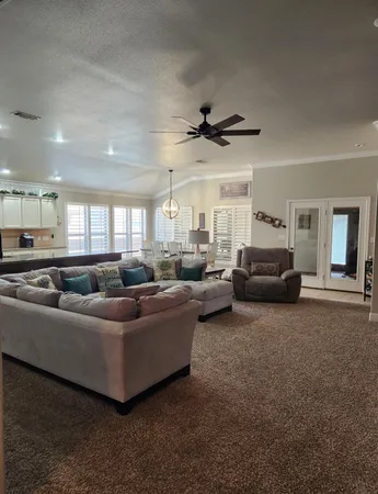 a living room with furniture and a ceiling fan