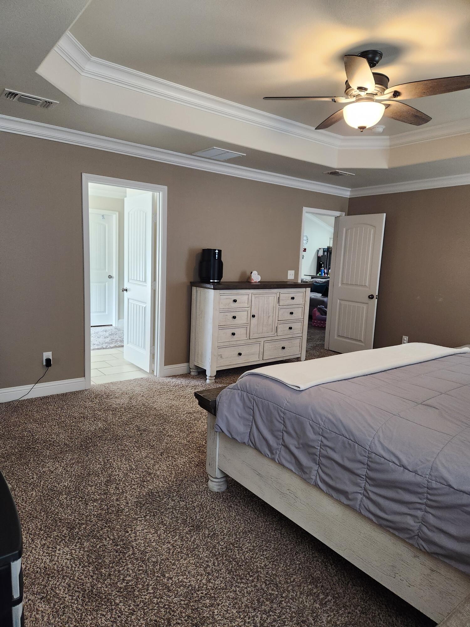 7217 91st Street Lubbock, TX 79424 - Photo 17 of 27 a bedroom with a bed and a chandelier