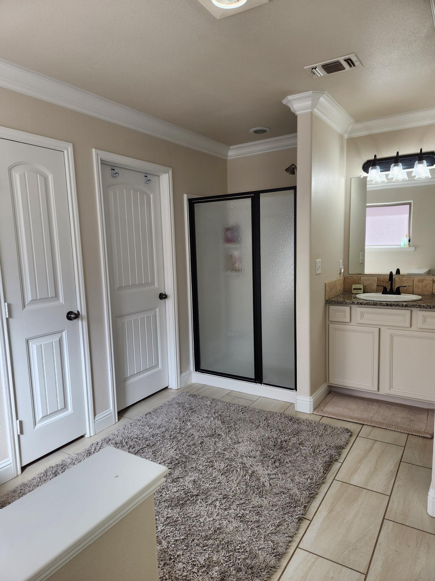 7217 91st Street Lubbock, TX 79424 - Photo 20 of 27 a spacious bathroom with a granite countertop sink and a mirror