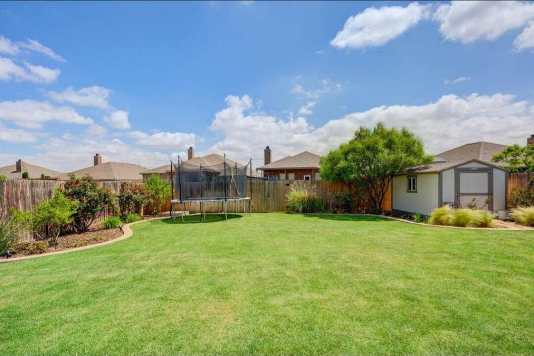 7217 91st Street Lubbock, TX 79424 - Photo 27 of 27 a view of a house with a big yard and large trees